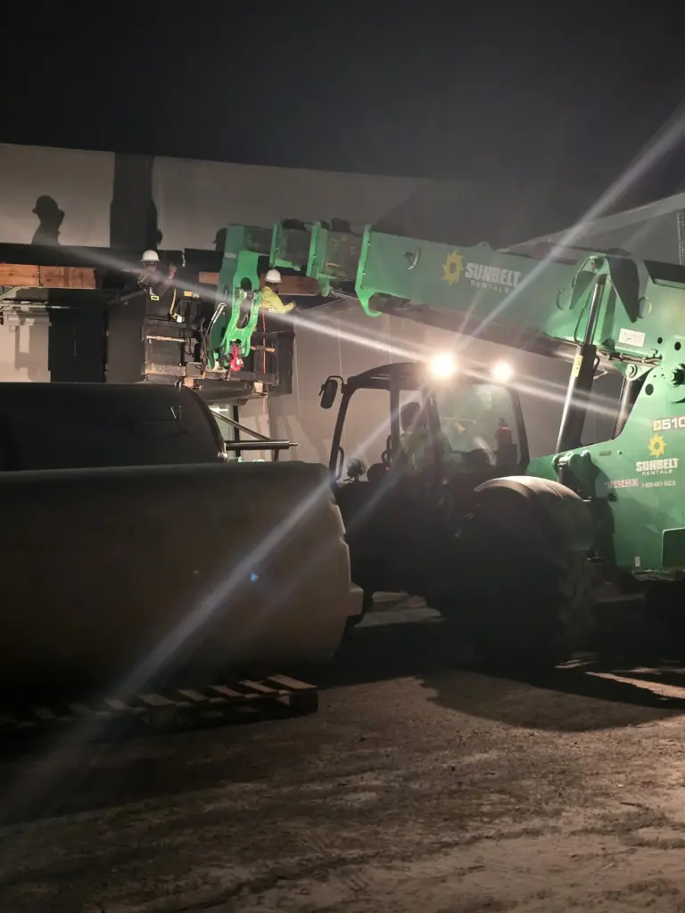 Night commercial roofing work with lift access